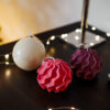 Bougies torsadees et boule nacree Decoration festive Ysadena Bougies torsadées rouges et violettes accompagnées d’une boule de Noël en cire nacrée