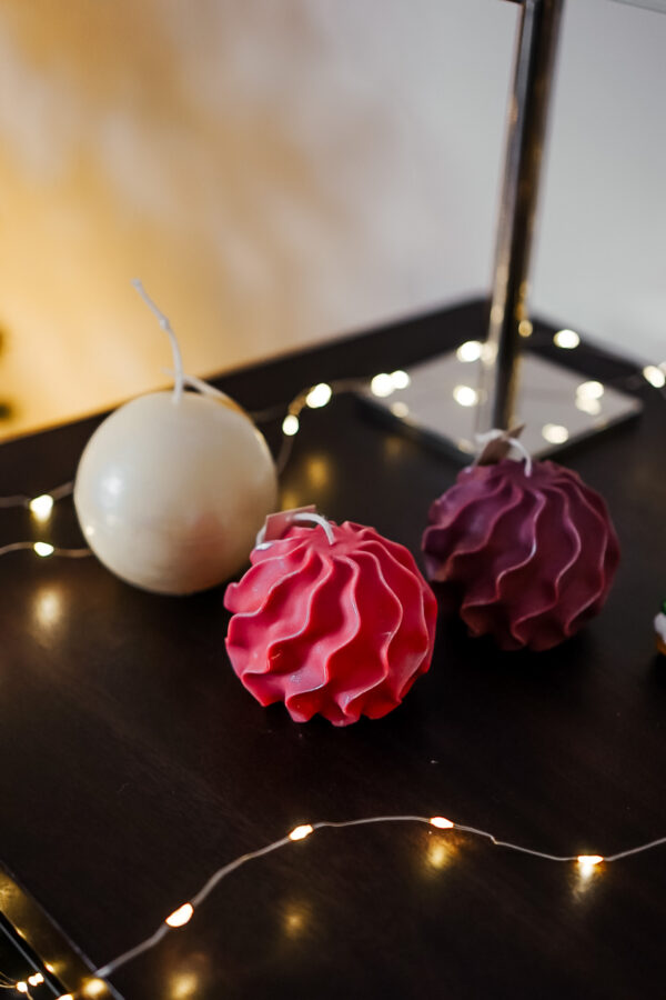 Bougies torsadees et boule nacree Decoration festive Ysadena Bougies torsadées rouges et violettes accompagnées d’une boule de Noël en cire nacrée